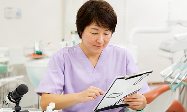銚子市の歯科医院で歯科医師が虫歯予防の音声台本を確認している診療室